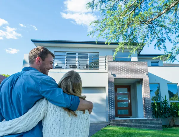 Couple standing outside their new home