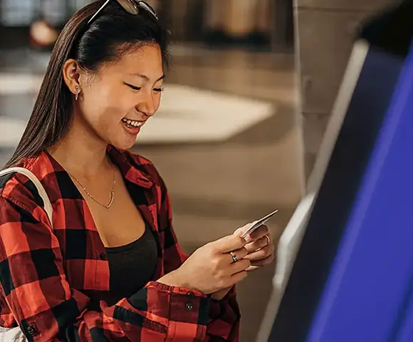 smiling asian woman using an atm